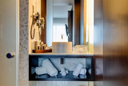 里斯本里斯本VIP Spa大酒店的浴室设有水槽和带毛巾的架子。