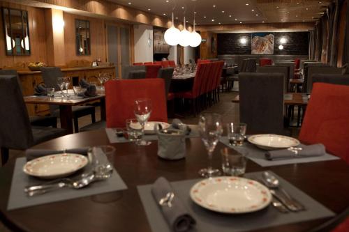 莱热贝尔维尤酒店的用餐室配有带盘子和玻璃杯的桌子
