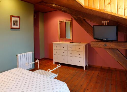 卢阿尔卡卢阿尔卡酒店的阁楼上的卧室配有床和电视