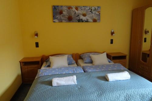 赫维兹Maxim Ház的一间卧室配有两张带毛巾的床