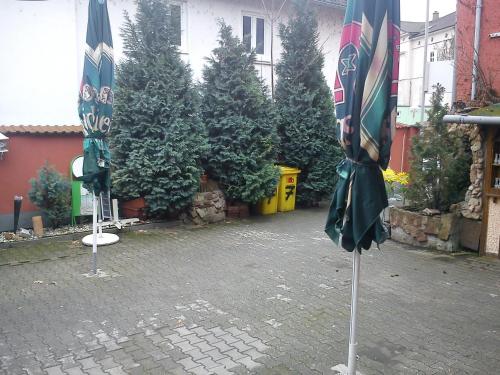 尼尔斯泰因楚库弗尔申科酒店的两把封闭式遮阳伞,位于一个种有树木的庭院