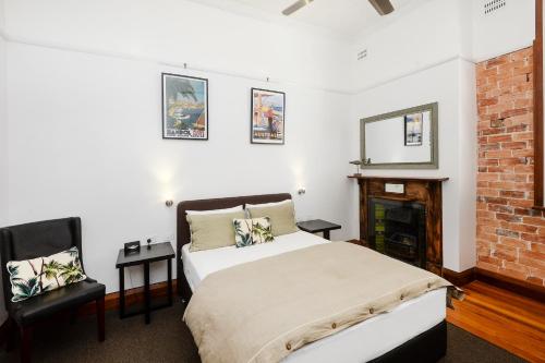 科夫斯港Pier Hotel Coffs Harbour的一间卧室配有一张床和一个壁炉