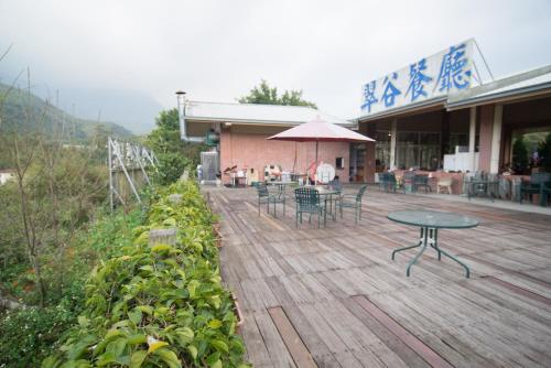 鹿谷乡翠谷山莊Cui Gu Villiage的一个带桌椅的庭院和一座建筑