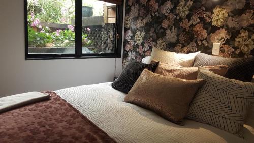 新普利茅斯Sequoia Steps的卧室配有带枕头的床铺和窗户。