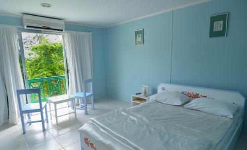 班佩罗勇府玛迈别墅酒店的一间蓝色卧室,配有一张床和一个阳台
