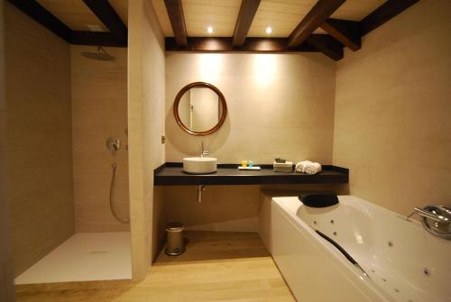 托尔拉布哈鲁埃洛酒店的一间带水槽、浴缸和镜子的浴室