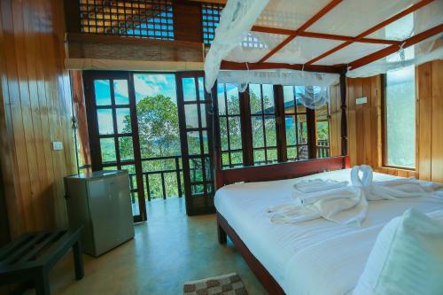 埃拉Tina Nature villa的一间卧室配有一张带白色床单和窗户的床。