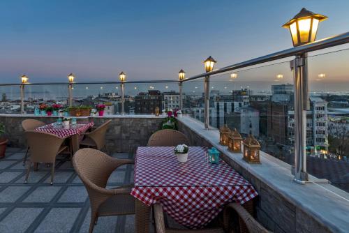 伊斯坦布尔厄尔巴兹拉尔酒店的市景阳台配有桌椅。