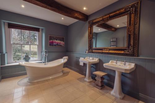 Lupton普拉夫宾馆的带浴缸、两个盥洗盆和镜子的浴室