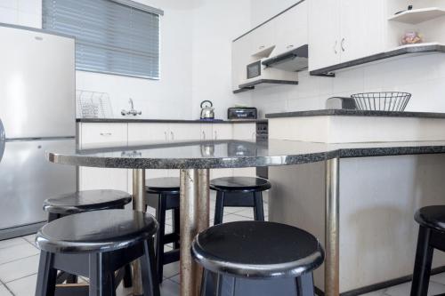 马盖特Seabrook 305 Margate RSA的厨房配有带凳子的柜台