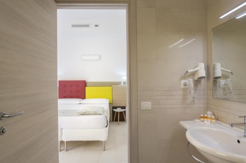 奥里斯塔诺TH collection rooms的一间带水槽的浴室和一张位于客房内的床