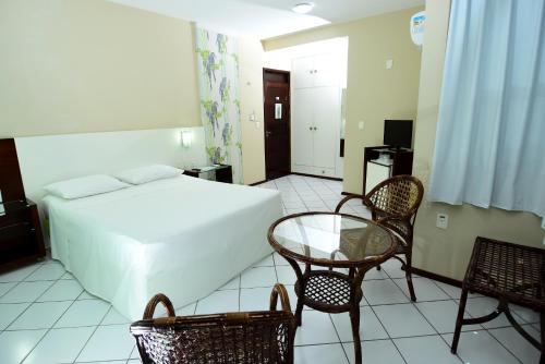 莫索罗帝国酒店的卧室配有一张床和一张桌子及椅子