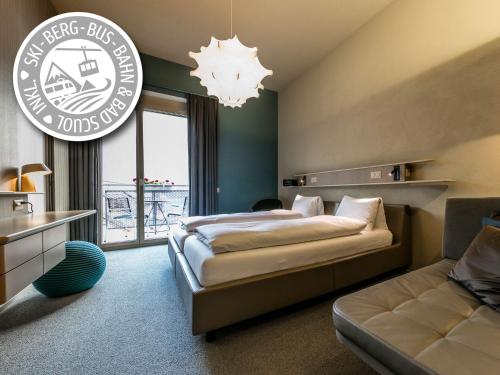 施库尔Badehotel Belvair的酒店客房,配有床和沙发