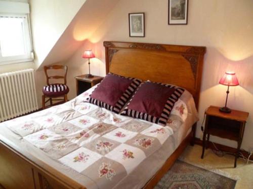 沙托兰Gite avec vue dominante的一间卧室配有一张大床、两张桌子和两盏灯。