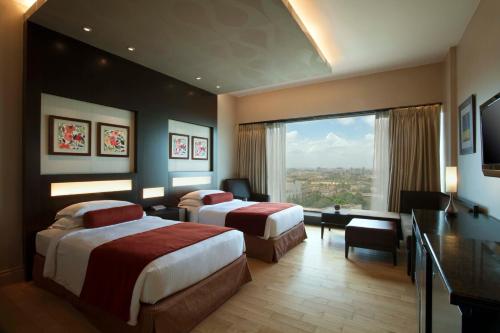 班加罗尔奥特拉酒店的酒店客房配有两张床和一张书桌