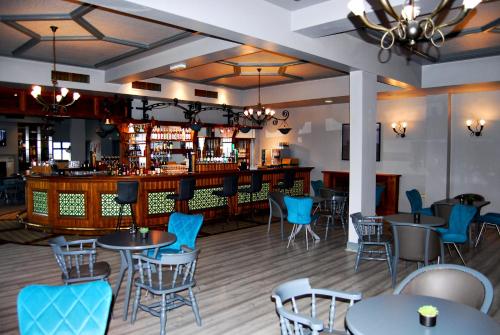 罗斯莱尔Coast Rosslare Strand的一间带桌椅的餐厅和一间酒吧