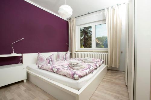 阿伦斯霍普Ferienwohnung Meerzeit的一间卧室配有一张紫色墙壁的床