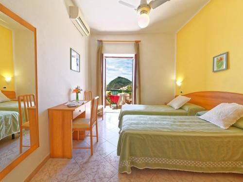 伊斯基亚弗兰茨别墅酒店​​的酒店客房设有两张床、一张书桌和一个窗户。