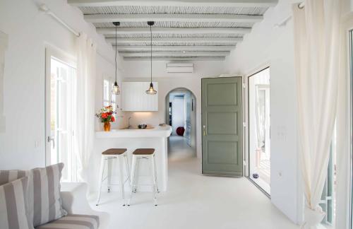 帕诺尔莫斯米科诺斯Mykonos Cocooning的厨房以及带绿门和凳子的客厅。