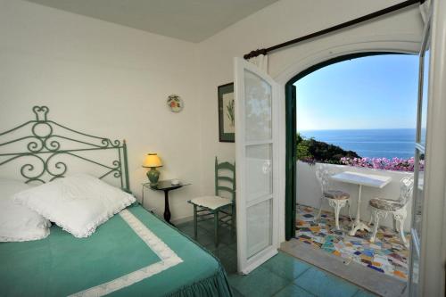 圣费利切-奇尔切奥朋塔罗萨酒店的一间卧室配有一张床,一扇门通往阳台