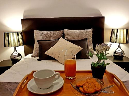 波尔图Oporto Cozy Studio的卧室配有带咖啡桌和茶的床铺