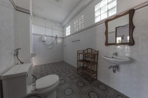 东德岛BABA酒店的白色的浴室设有卫生间和水槽。
