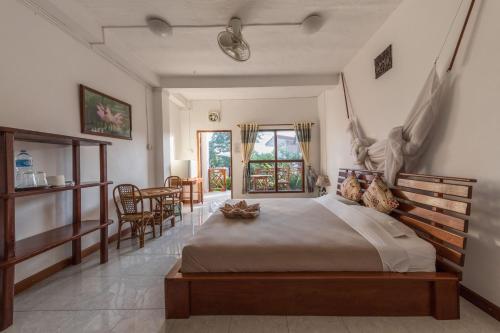 东德岛BABA酒店的一间卧室配有一张大床和一张桌子及椅子