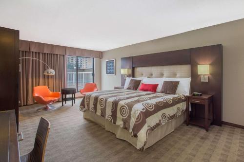 基洛纳基洛纳华美达会议中心酒店的酒店客房设有一张大床和一张书桌。