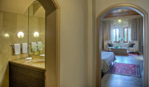 拜特丁米尔阿明宫酒店的一间带水槽的浴室和一张位于客房内的床