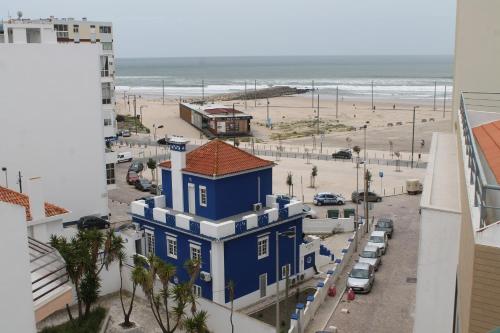 卡帕里卡海岸雷尔卡帕里卡酒店的蓝色建筑,背面有海滩