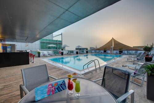 迪拜J5酒店 - 赛义德港的一个带桌椅的游泳池和一个桌药师yasteryasteryasteryasteryasteryastery