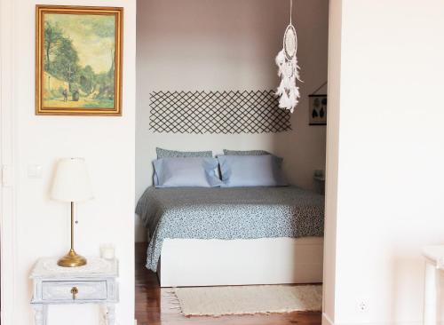 里斯本Casa da Varanda Simpática的一间卧室配有一张带蓝色枕头的床