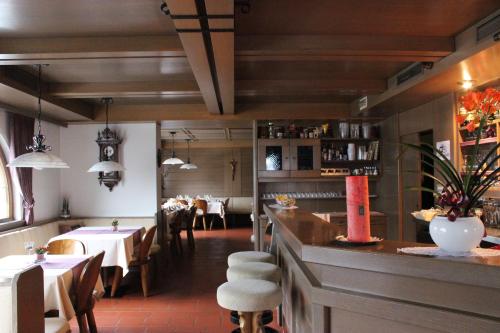 奥蒂塞伊Villa Luise的一间带桌椅的餐厅和一间酒吧