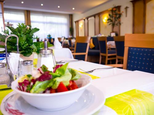 巴特基辛根维托埃里卡酒店的餐厅桌子上放一碗沙拉