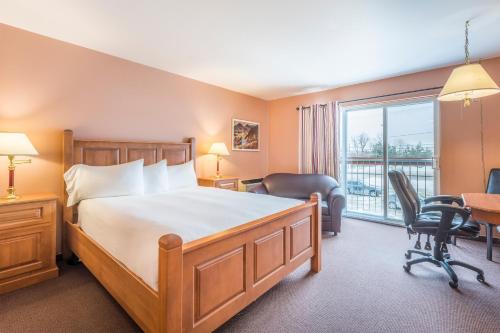 拜圣保罗圣保罗湾酒店的一间卧室配有一张床、一张书桌和一个窗户。