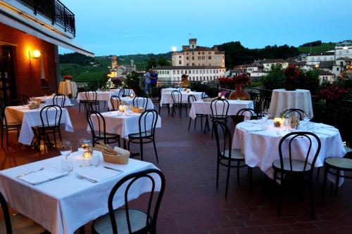 巴罗洛Hotel Barolo Classico的一间设有白色桌椅的餐厅,享有美景