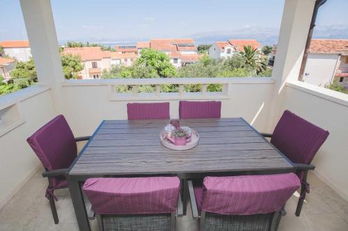 苏佩塔尔Salsa的阳台上配有一张带紫色椅子的木桌
