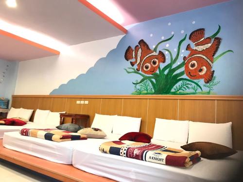 南湾南湾KiKi民宿的墙上画画的房间里设有两张床