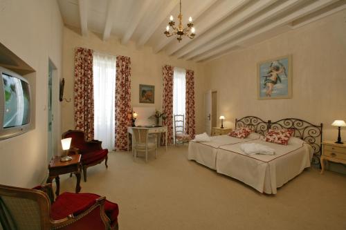 圣保罗－代斯皮圣让庄园酒店的一间卧室配有两张床、一把椅子和一张桌子