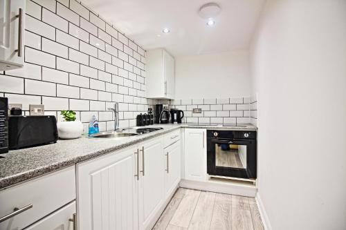 伊普斯威奇Star Apartment的白色的厨房设有水槽和炉灶。