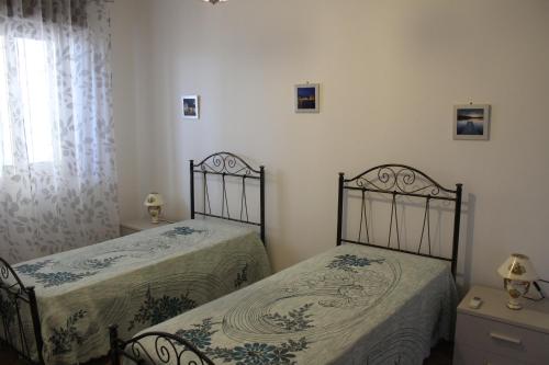 梅利萨诺Holiday Home Giovanna的一间卧室设有两张床和窗户。