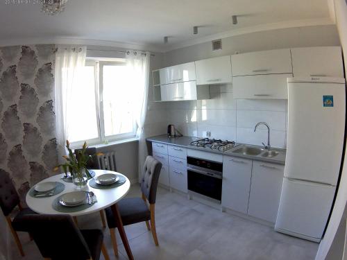 琴斯托霍瓦Apartament Jasny的一间带桌子和白色冰箱的小厨房
