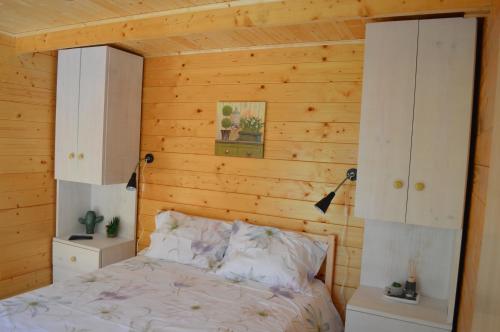 阿格达Bamboo Guest House的一间卧室设有木墙、一张床和橱柜