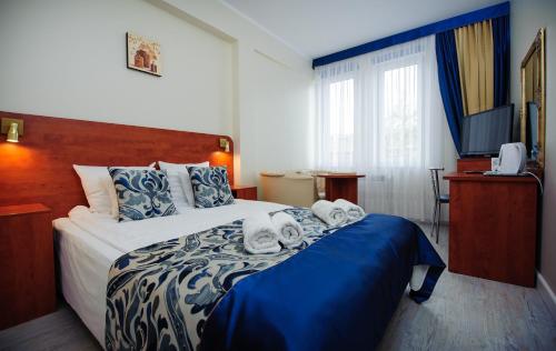 切霍齐内克Abidar Hotel Spa & Wellness的酒店客房,配有带毛巾的床