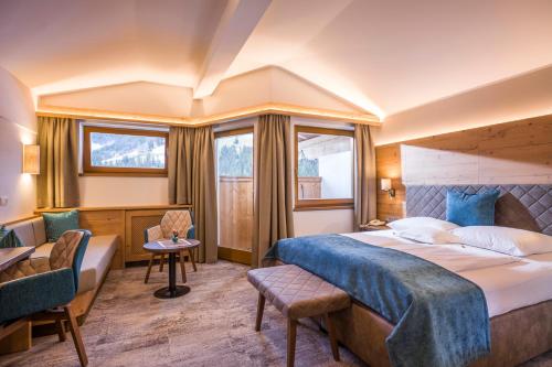 奥贝劳Hotel Bergkristall的配有一张床和一张书桌的酒店客房