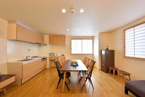 京都ShukuShuku的厨房以及带桌椅的用餐室。