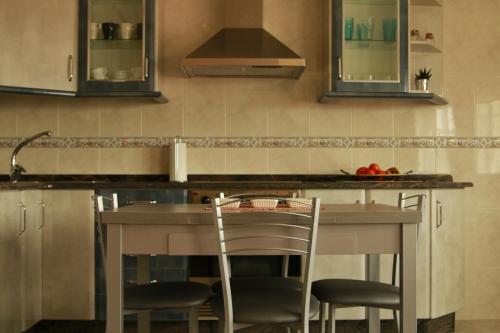 奥亚Casa Toñi的厨房配有带2把椅子和水槽的台面