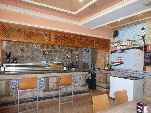 加鲁查Hostal Cortés的餐厅设有配备橙色椅子的酒吧