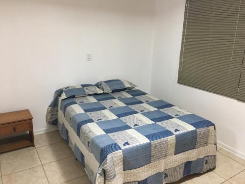 卡洛斯-巴尔博萨Confortável Residencia em Carlos Barbosa的卧室内的一张床位,配有蓝色和白色的毯子