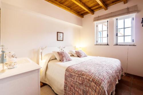 格兰杜拉Monte do Medronhal的白色的卧室设有床和窗户